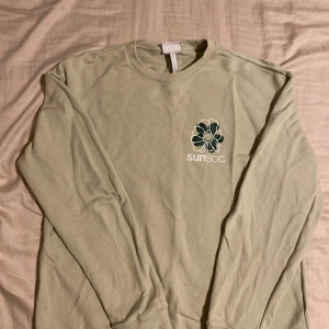 Grön Sunsoc sweatshirt från H&M  - Säljer en ljusgrön tröja från H&M i storlek L men den sitter mer som M. Fint skick. Tveka inte på att höra av dig om du har frågor eller vill ha fler bilder!