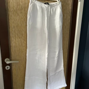 Vita linnebyxor med dragsko - Säljer ett par superbekväma vita linnebyxor. De har en avslappnad passform med breda ben och en elastisk midja med dragsko för extra komfort. Perfekta för sommardagar eller en avslappnad dag hemma. 🏖️
