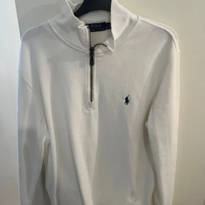 Ralph Lauren Halv-Zip - Säljer en vit halv zip från Ralph Lauren. Den är väldigt bekväm men är lite för stor för mig. Den är storlek L men passar även M. Skick 10/10.