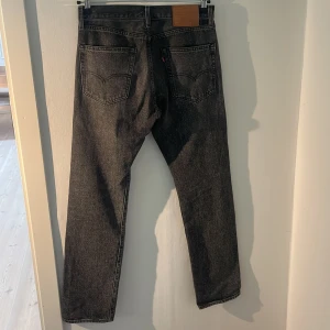 Svarta jeans från Levi's - Säljer ett par klassiska svarta Levi's jeans, modell 551. De är i bra skick och har en snygg, rak passform. (Skick 8/10) då jag endast använd dom ett fåtal gånger. Hör gärna av er vid frågor eller funderingar!