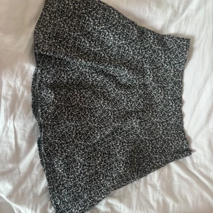 Svart vit blommig kjol  - Säljer min korta blommiga kjol från zara i storlek xs. Kjolen har dragkedja där bak för att kunna sättas på. Använd ett fåtal gånger🥰 