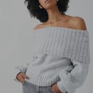 Stickad off shoulder tröja i ljusgrå  - Stickad tröja i nyckick från gina tricot. Tröjan är off shoulder i ett grövre stickad material med en vik ovankant. Den har ribbstickning kring halsringningen och i nederkant. Perfekt till hösten💕