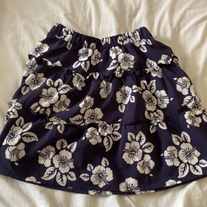 Blå kjol med blommor på🩵💙 - Säljer en blå kjol med vita blommor på för att den är förliten. Den är i jätte fint skick🩵