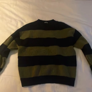 Randig tröja i grönt och svart - Säljer en snygg och bekväm randig tröja från arkets barnavdelning, den är väldigt stor i storleken så skulle säga att den passar folk som bär xxs-xs 