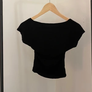Svart t-shirt med öppen rygg - Superfin svart topp med öppen rygg. Går ungefär till naveln och har hyfsat tunt tyg💕