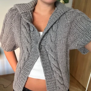 Grå virkad kofta - Grå virkad kofta som både går att ha som tröja stängd samt öppen som en kofta.