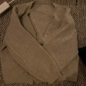Stickad cardigan - Stickad cardigan i fint skick då den ej är använd! Jättevarmt och fin grå beige färg😍