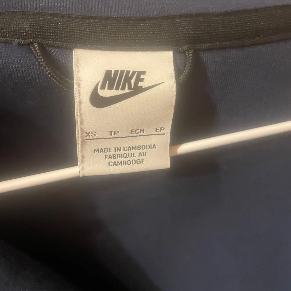 Säljer en mörkblå jacka från Nike i storlek XS. Den har en dragkedja framtill och en huva för extra skydd. Perfekt för kyliga dagar och har en stilren design.. Jackor.