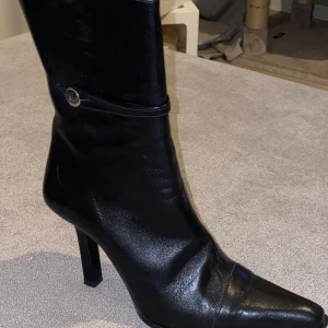Vero cuoio stövlar italienskt läder - Snygga svarta stövletter från Vero Cuoio med spetsig tå och hög klack. Stövletterna har en dragkedja på insidan och en knappdetalj på skaftet. Italienskt läder Nypris: 1450:- Storlek: 36 Endast testade inomhus