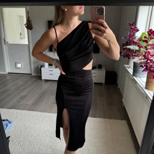 Svart klänning i storlek S - Svart klänning från Shein i storlek S. Använd Använd 2-3 gånger, som ny. Något genomskinlig (se bild). Väldigt stretchigt tyg som följer kroppen. Reglerbart axelband. Slits vid ena benet. Min längd 174 cm.