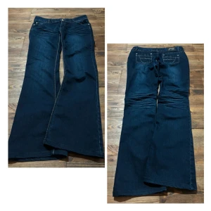 Marinblå bootcut lågmidjade jeans - Super coola lågmidjade bootcut marinblå jeans med snygga detaljer♡  Pris går att diskutera!☆  Mått:  Midjebredd-41cm  Total längd-105cm