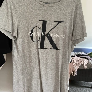 Grå Calvin Klein T-shirt  - Näst intill oanvänd, i nyskick. Den är storlek S men passar på mig som ofta är en M