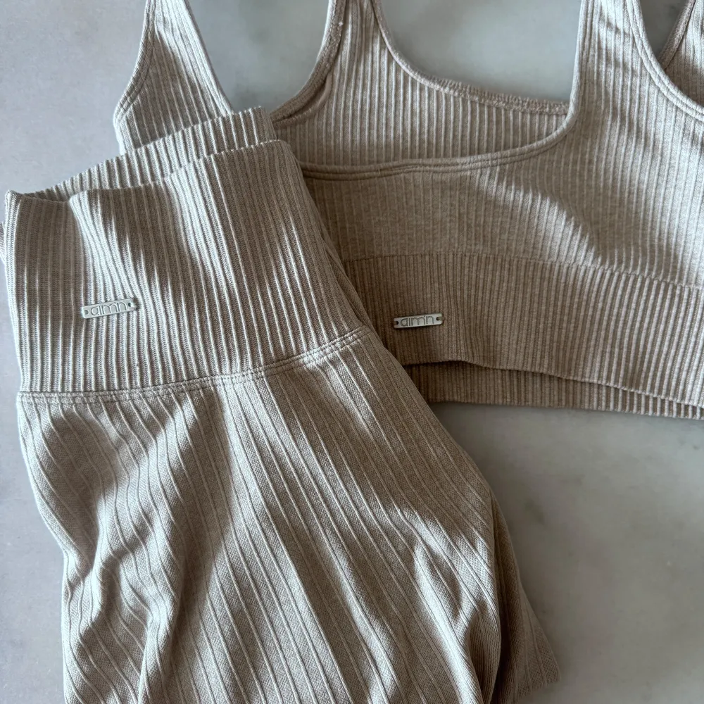 Säljer ett beige ribbed seamless set från Aimn strl XS. Det har en tight passform, perfekt för träning eller en avslappnad dag hemma. Materialet är mjukt och stretchigt, vilket gör den väldigt bekväm att bära. . Sportswear.