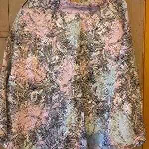 Mönstrad klänning från Pinup Couture - Säljer en unik och färgglad klänning från Pinup Couture i storlek S. Klänningen har ett vackert mönster med blad i olika pastellfärger som rosa, blå och grön. Den har en dragkedja i ryggen för enkel på- och avtagning. Perfekt för en somrig fest eller en dag ute i solen!