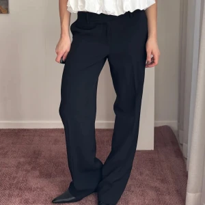 Svarta kostymbyxor - Snygga svarta kostymbyxor med en klassisk rak passform. Perfekta för en stilren look. Byxorna har en låg midja använda ca 2 gånger 
