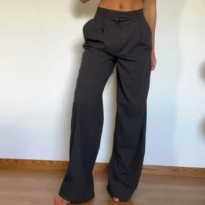 Grå kostymbyxor från Mango - Snygga grå kostymbyxor från Mango med vida ben. Uppsydda, jag är 163 cm lång.