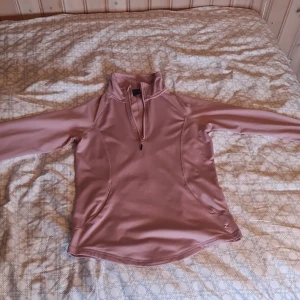 Ridtröja från Horze - Säljer en rosa tröja från Horze med halv dragkedja och hög krage. Perfekt för kyligare dagar med sin långa ärmar och bekväma passform. Tröjan har en stilren design och är idealisk för ridning. Tröjan är i bra skick lite lång men bekväm att rida i. 