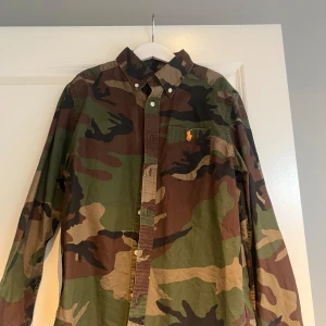 Camouflage skjorta från Ralph Lauren - Säljer en fet camouflage skjorta från Ralph Laurent storleken är 150 men ganska liten i storleken   Perfekt för en avslappnad stil.