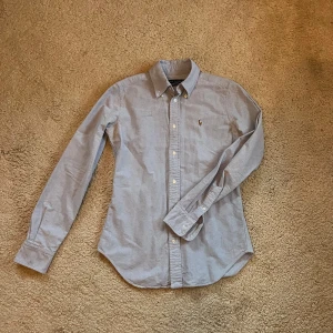 Ljusblå skjorta från Ralph Lauren - Säljer en stilren ljusblå skjorta från Ralph Lauren i super slim fit. Perfekt för en elegant look till sommarn. Nypris cirka 1500. Vill få såld. 