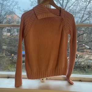 Rosa stickad tröja från Massimo Dutti - Säljer en snygg rosa stickad tröja från Massimo Dutti. Tröjan har en unik krage med knappar och långa ärmar. Perfekt för kyligare dagar. Passar bra till både jeans och kjol. 🌸