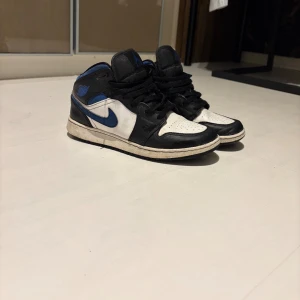 Nike Air Jordans i svart, blå och vit - Snygga Nike Air Jordans i en klassisk färgkombination av svart, blå och vit. Skorna har en ikonisk design med snörning och en bekväm passform. Perfekta för dig som vill ha en stilren look. Det har en liten difekt som du ser på bild 4. Pris kan diskuteras vid snabb affär!