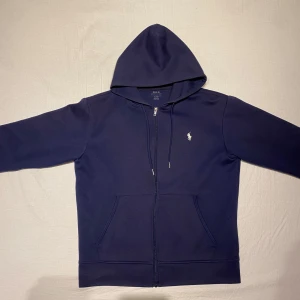 Polo Ralph lauren zip-up hoodie - Polo Ralph lauren zip-up hoodie i bra skick. Använt den relativt mycket och den har missfärgats lite därför säljer jag den. 