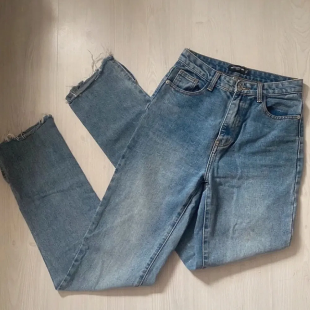 Blå jeans med slits från PrettyLittleThing i storlek 36. Se bild för mått vid midjan! Innerbenslängden är 89cm! De knäpps med dragkedja och knapp.. Farkut & Housut.