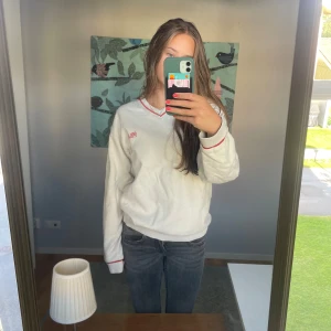 Fila sweatshirt - V-ringad Fila sweatshirt i beigegrå med orangea detaljer. I strl S men passar XS-M. 