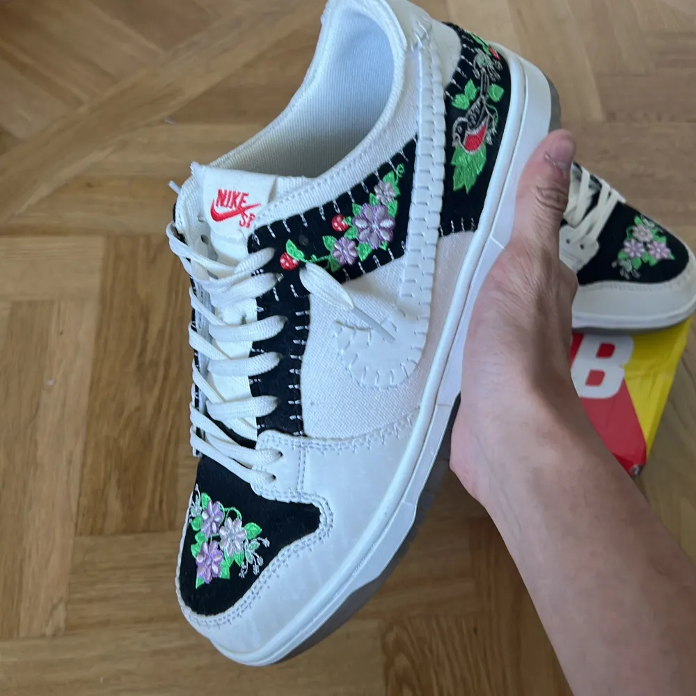 Säljer ett par snygga Nike Dunk sneakers i storlek 43. Skorna är vita med svarta detaljer och har ett coolt blommigt mönster på sidorna och tån. De är i bra skick. Kommer med originalkartong. Priset kan diskuteras. Vid snabb affär 650kr . Skor.