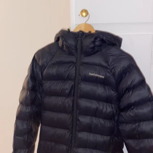 Svart dunjacka från Peak Performance - Säljer en svart dunjacka från Peak Performance. Köpt för 3400. Jackan är i nyskick och har en normal passform. Den är långärmad och har en dragkedja framtill. Perfekt för vintern då den är väldigt varm och skön. Jackan har en huva och är quiltad för extra värme. Köp direkt eller ge prisförslag!