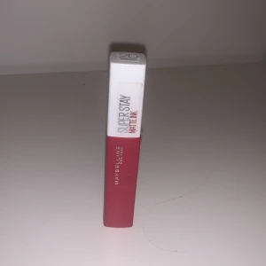 Maybelline SuperStay Matte Ink läppstift - Säljer ett Maybelline SuperStay Matte Ink läppstift i en snygg röd nyans. Läppstiftet har en långvarig formula som håller hela dagen utan att smeta ut. Applikatorn är precis och gör det enkelt att applicera färgen jämnt. Perfekt för både vardag och fest!