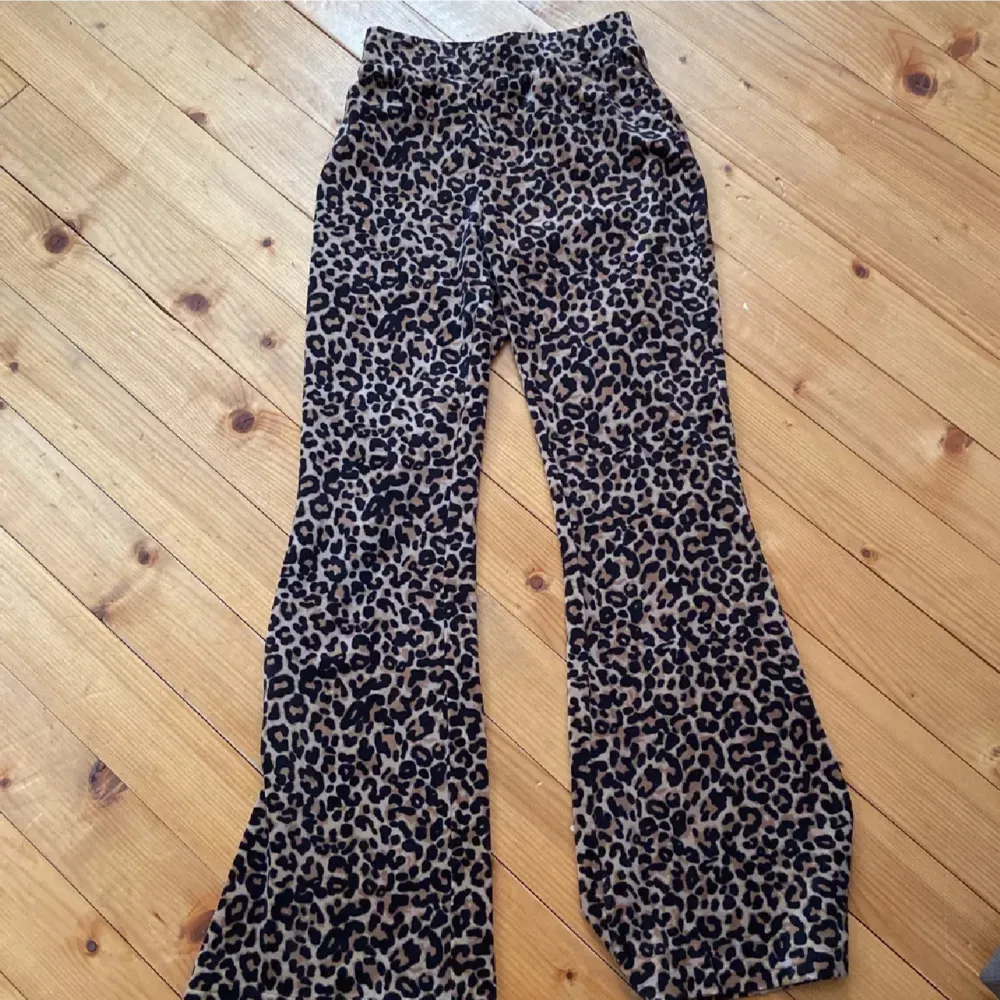 Säljer ett par snygga leopardmönstrade byxor. Dom har en bootcut-stil som ger en cool och trendig look. Materialet känns mjukt och bekvämt, perfekt för både vardag och fest. Byxorna är i toppskick och redo att bäras av någon som vill sticka ut! . Jeans & Byxor.