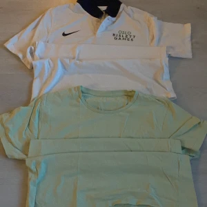Vita och ljusgröna t-shirtar - Säljer en vit pikétröja från Nike med Oslo Bislett Games-tryck och en ljusgrön t-shirt. Pikétröjan har en svart krage och knappar framtill, perfekt för sportiga tillfällen. T-shirten är enkel och bekväm, idealisk för vardagsbruk. Båda i bra skick! 20 för båda
