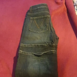 Mörkblå jeans med broderad bakficka - Säljer ett par snygga mörkblå jeans i bra skick. De har en cool broderad detalj på bakfickan och klassisk femficksdesign. Perfekta för både vardag och fest! Passar till allt och är superbekväma.