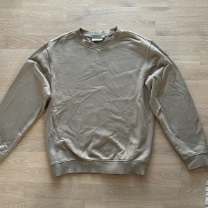 Beige sweatshirt feån Weekday - Säljer en stilren beige sweatshirt i bra skick. Perfekt för både höst och vår. Tröjan har långa ärmar och en klassisk rund halsringning. Den är gjord i ett mjukt bomullsmaterial som är superbekvämt att ha på sig. Passar perfekt till vardags eller en avslappnad dag ute.
