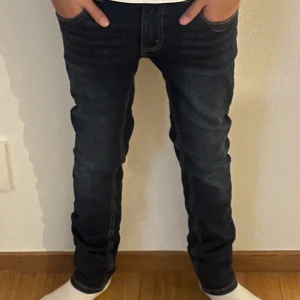 Mörkblå jeans från Levi's 12a - Säljer ett par snygga mörkblå jeans från Levi's i bra skick. De har en slim passform och är perfekta för både vardag och fest. Klassisk fyraficksdesign med dragkedja och knapp. Passar perfekt till en casual look eller med en snygg skjorta för en mer uppklädd stil. Skicket på denna par jeans är nästan helt nya och har används 1-2 gånger 9/10 skick storleken är 12år.👏