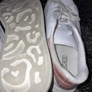 Säljer ett par vita sneakers från M Shoes i bra skick. De har snygga rosa detaljer på hälen och klassisk snörning. Perfekta för vardagsbruk och ger en stilren look. Sulan har ett unikt mönster som ger bra grepp.