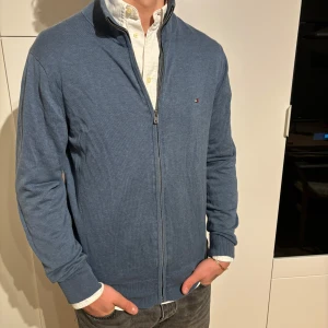 Blå kofta från Tommy Hilfiger M - Blå kofta från märket tommy hilfiger storlek M. Bra använt skick, inga defekter men lite urtvättad. Modell på bild är 182/67kg. Hör av dig vid eventuella frågor! Mvh CAVI