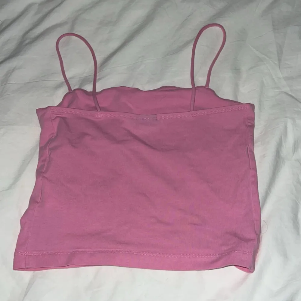 Säljer en söt rosa linnetopp i bomull. Perfekt för sommardagar eller som ett lager under en tröja. Den har smala axelband och en enkel design som gör den lätt att matcha med olika outfits.. Yläosat.