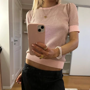 Rosa stickad topp - Säljer en superfin rosa stickad topp med korta ärmar och ett diskret mönster. Toppen är rosa/guldig med glitter i💖Den är i mycket bra skick och har ribbade kanter vid ärmslut och nederkant🎀