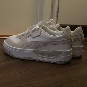 Vita sneakers från Puma - Säljer ett par snygga sneakers från Puma i nytt skick. De har en chunky sula och klassisk snörning. Perfekta för både vardag och fest!Köpta för 1200kr säljer för 500kr