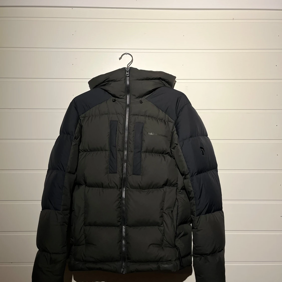 Mörkgrön dunjacka från Peak Performance.
