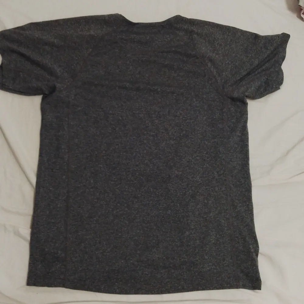 Säljer en mörkgrå t-shirt i mycket bra skick. Den är kortärmad och har en normal passform, perfekt för både vardag och träning. Materialet känns mjukt och bekvämt mot huden. Enkelt och stilrent plagg som passar till det mesta. Perfekt för dig som gillar en minimalistisk stil.. T-paidat.