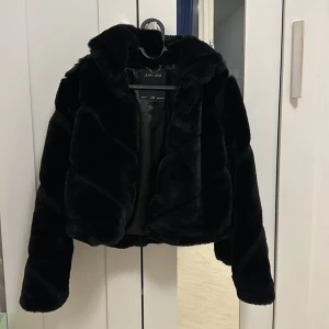 Svart pälsjacka från Amisu - Säljer en supermjuk och fluffig svart pälsjacka från Amisu. Perfekt för att hålla sig varm och stilren under kyliga dagar. Jackan har en klassisk design med långa ärmar och en bekväm passform. Passar både till vardags och festliga tillfällen. 🖤