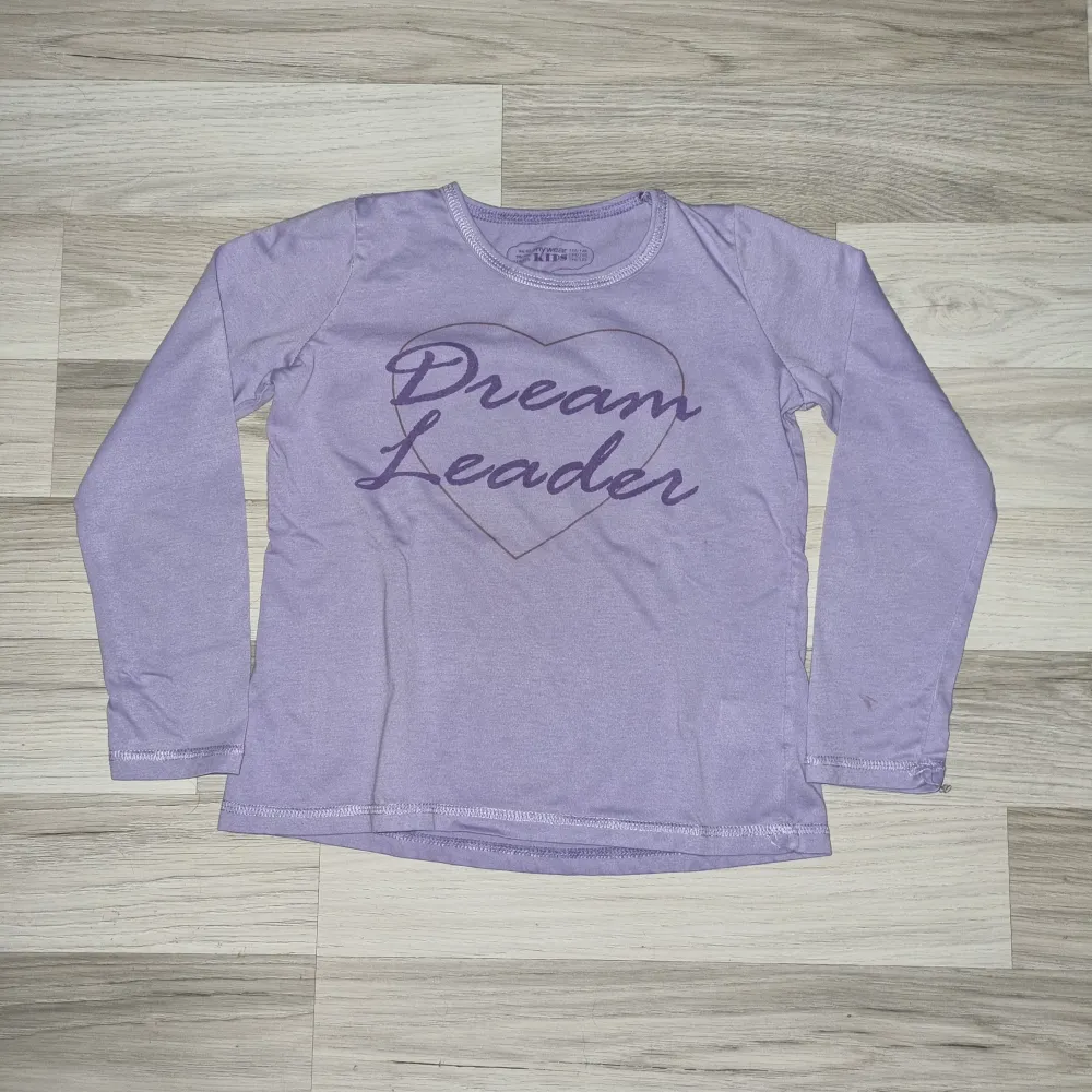 Säljer en söt lila långärmad pyjamas med långbyxor från Mywear Kids med texten 'Dream Leader' tryckt på framsidan. 💜. Tröjor & Koftor.