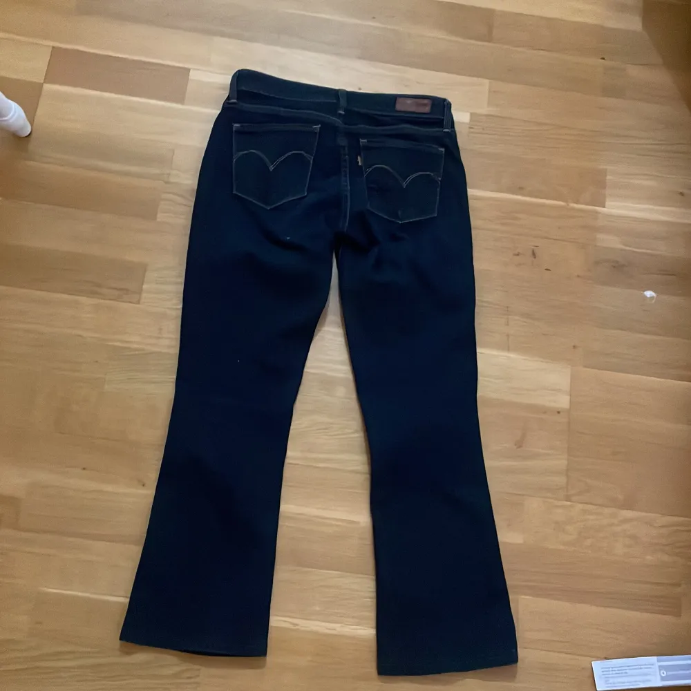 Säljer ett par snygga mörkblå jeans från Levi's i bootcut-stil. De har en klassisk femficksdesign och en läderpatch baktill. Perfekta för både vardag och fest!💗💗. Jeans & Byxor.