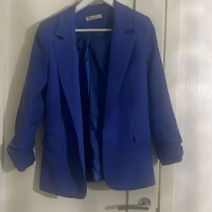 Blå kavaj från frendy - Säljer en snygg blå kavaj från frendy. Den har en klassisk design med långa ärmar och fickor framtill. Perfekt för både vardag och fest! 💙