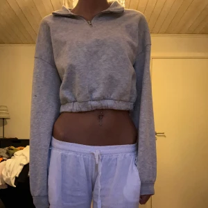 Grå croppad hoodie - Säljer en supermysig grå croppad hoodie med dragkedja. Perfekt för en chill dag hemma eller en avslappnad promenad. Den har långa ärmar och en bekväm passform. Passar perfekt till höst och vår. 🩶