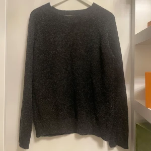 Mörkgrå stickad tröja - Säljer en mysig mörkgrå stickad tröja i bra skick. Perfekt för kyliga höst- och vinterdagar. Tröjan har långa ärmar och en klassisk rund halsringning. Passar både till vardags och lite finare tillfällen. Ett måste i garderoben för den som älskar stilren design!