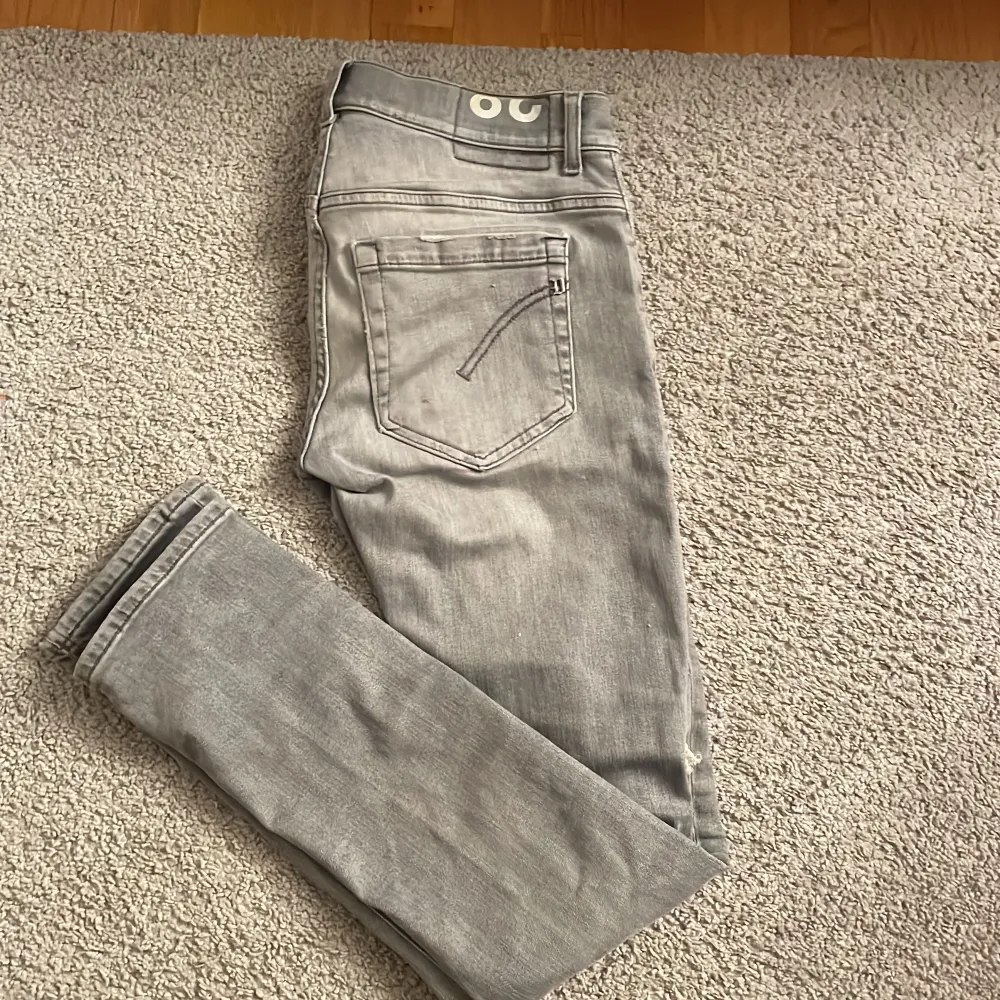 Säljer ett par grå slim jeans ifrån Dondup med modell George i storlek 28. De är i skick 9/10. De har en schysst reva på ena benet. Beninnerlängd 76 cm och midjemått 36 cm. Passar dig som är runt 170-172 cm lång. Hör av dig ifall du har några frågor!. Jeans & Byxor.